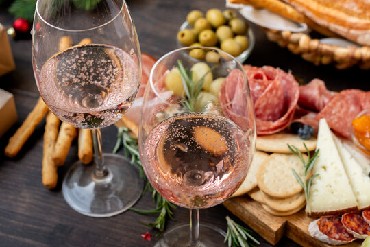 festive aperitif or party two glasses of champagne, Prosecco or ros&eacute; wine with cold meat appetizers cheeses and olives