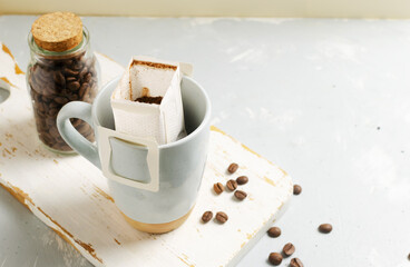 The process of brewing a bag Drip coffee into a cup on a gray background. A quick way to prepare a...