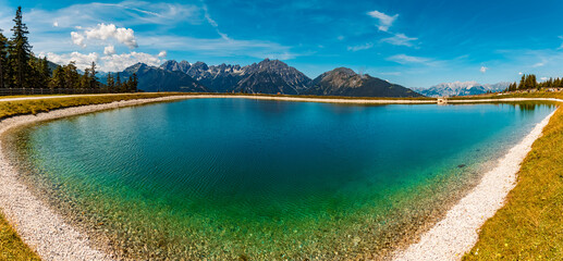 High resolution stitched alpine summer panorama with reflections in a lake at Serles cable car...