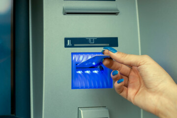 Need some money. Close-up view of female hand using her credit card at the ATM