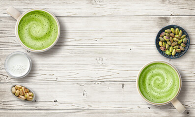 Pair of two matcha lattes and pistachio nut on a rustic table top