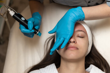 Woman receiving hydrafacial treatment in beauty salon