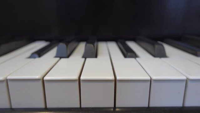 A self-playing piano, also called a pianola, with black and white keys playing a tune automatically. 