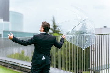 雨の日に傘をさす外国人ビジネスマン（梅雨・台風・雨上がり・異常気象）
