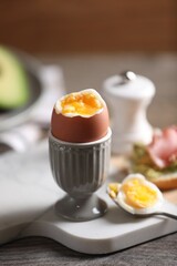 Soft boiled chicken egg served on wooden table