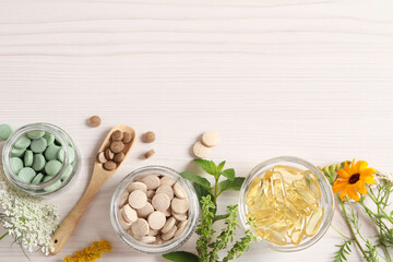 Different pills, flowers and herbs on white wooden table, flat lay with space for text. Dietary...