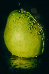 Image of a ripe pear with water droplets. Still life.