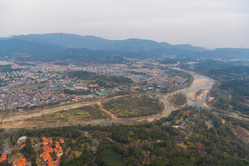Obraz premium The view on the village by the river from Da Wang Shan Peak in Fujian, China