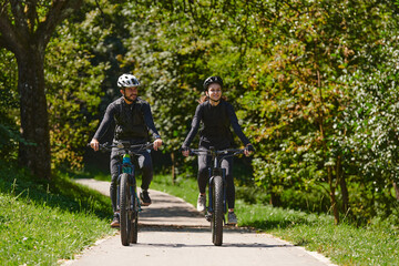 Obraz premium A blissful couple, adorned in professional cycling gear, enjoys a romantic bicycle ride through a park, surrounded by modern natural attractions, radiating love and happiness