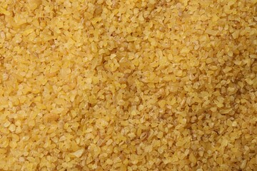 Pile of raw bulgur as background, top view