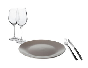 Clean plate, cutlery and glasses on white background