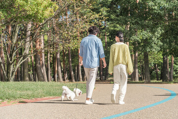 愛犬を可愛がる飼い主の親子・犬の散歩（父親と娘）
