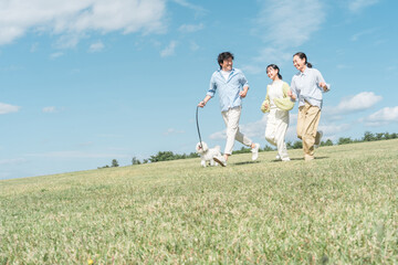 犬・ペットと遊ぶ家族・ファミリー（両親と子供・3人）
