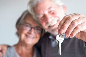 couple of two seniors after buy a new house or car and go to live together - man holding a key and...