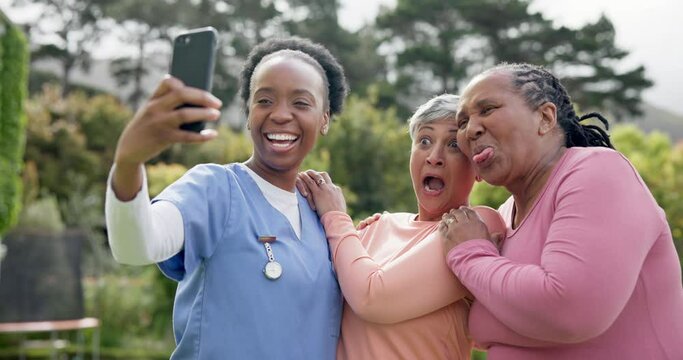 Nurse, women and crazy selfie in garden with happy, retirement village and outdoor laughter in sun. Nurse, diversity and old people with smartphone for memory, nature and social media with comedy