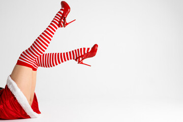 Sexy Santa woman legs in red shoes and striped socks