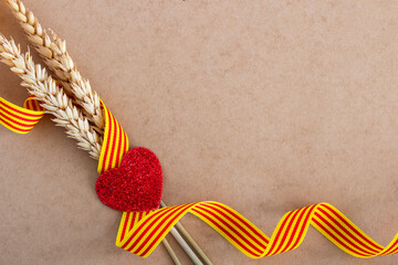 Flag of Catalonia. Celebration of the Catalan festivity, with three ears of wheat, a ribbon with the flag of Catalonia and a red glitter heart. Diada de Catalunya	