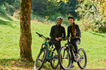 Obraz premium A blissful couple, adorned in professional cycling gear, enjoys a romantic bicycle ride through a park, surrounded by modern natural attractions, radiating love and happiness
