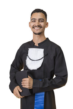 Jovem pardo de barbicha, sorridente, magro, com beca de formatura e segurando o chap&eacute;u de formatura ao seu lado. Pose confiante. Felicidade.