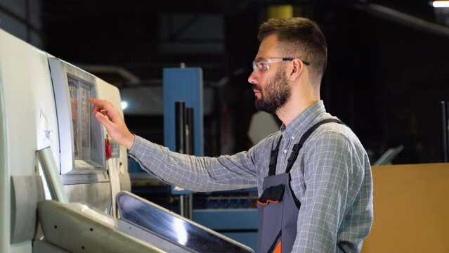 Print house worker setting parameters on modern offset printing machine