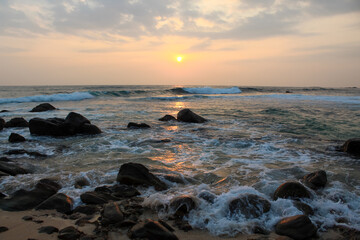 The sun setting into the sea at Delawella beach, Sri Lanka. Golden light