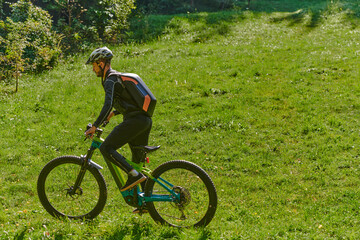 Fototapeta premium In the radiant glow of a sunny day, a fitness enthusiast, donned in professional gear, pedals through the park on his bicycle, embodying strength and vitality in a dynamic outdoor workout