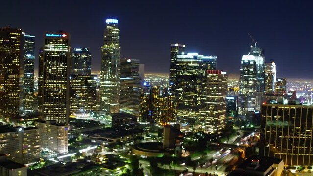 Aerial Panning Shot Of Sparkling Modern Buildings In Financial District, Drone Flying Backwards At Night - Los Angeles, California