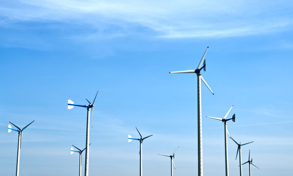 Windmills are active under the sunlight with the background of beautiful sky, landscape images of windmills, and concepts for green energy.