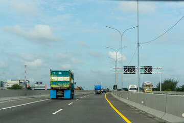 Transportation trucks in high speed driving at the highway. view of Jalan Tol Trans Sumatera (Trans Sumatera Toll Road) in Medan, North Sumatera.