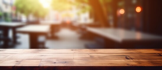 Bokeh image with blurred background of coffee shop and empty brown wooden table in focus