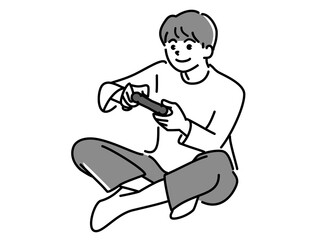 あぐらをかいてゲームをする男の子　モノクロ