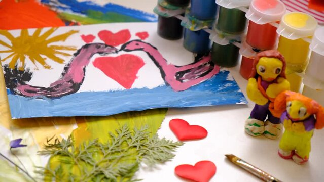 Child painting  couple swan, hearts, making crafts from paper. Handmade concept for birthday, mothers day or Valentines day. Education. Inspiration and imagination
