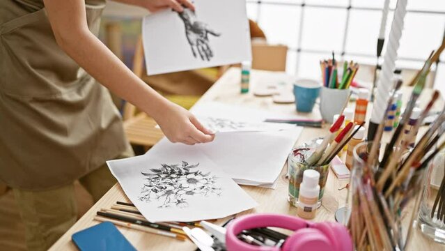 Hispanic woman artist's hands holding draws amid art session in studio, canvas easel painted passionately