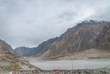 Valley between mountains on a cloudy day. A Dried river trains of Shyok river in Nubra Valley in Ladakh Region of Indian Himalayan territory .A  Barren landscape of Cold dessert in Himalaya Valley .