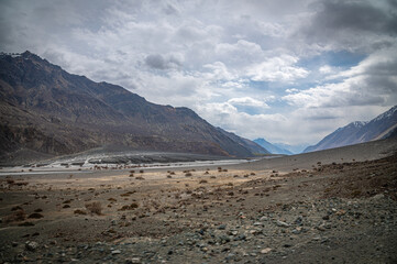 Scenic view of Himalayas and Ladakh ranges. Beautiful barren hills in Ladakh with dramatic clouds in the background.  View from the road from Nubra Valley to Turuk. Siachen area in Leh Ladakh.