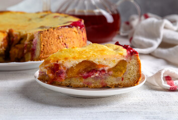 Homemade tart with yellow plums, raspberries and curd cream on a light background