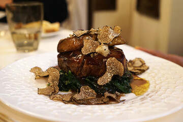 Close up Beef steak filet served with sauteed spinach, port sauce, Foie Gras and sliced black truffle © chettarin
