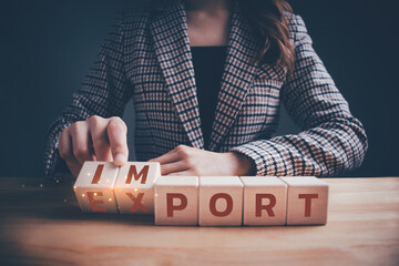 Businesswoman hand flipping wooden blocks with IMPORT to EXPORT text. International trade business, logistics business, industrial trade relations, importing and exporting strategies concept. - obrazy, fototapety, plakaty