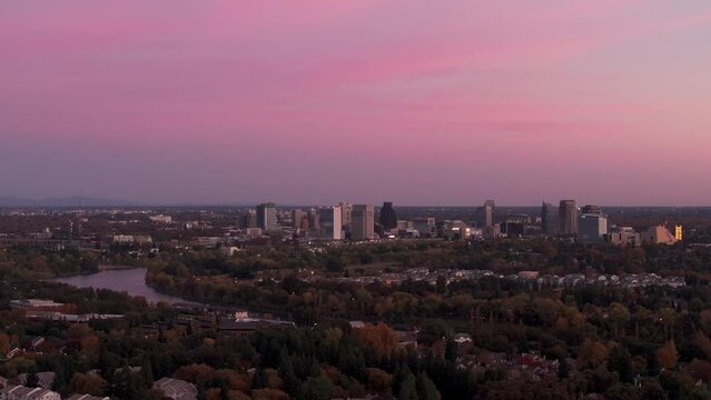 Stationary drone shot of downtown Sacramento, California with pink and red sky