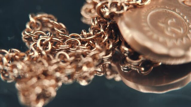 A smooth detailed macro tilt down shot of a golden medallion necklace, flying bird in the middle of the sun symbol, on a rotating stand, mirror reflection, professional studio lighting, 4K video