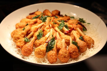 Fried chicken with sweet and sour sauce in a white bowl.