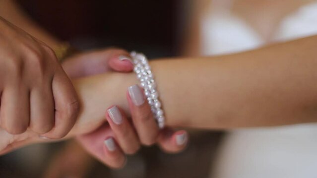A bride getting ready for her wedding by wearing her bracelet extreme closeup