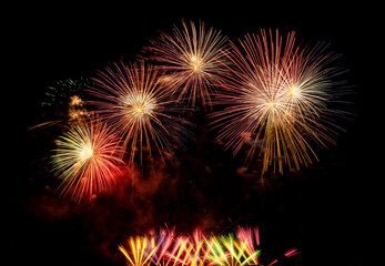 Obraz premium Fireworks show under defocus or blur concepts with isolated black background at night, this celebration is for the International Fireworks Festival in Pattaya on Nov 24-25 in Thailand