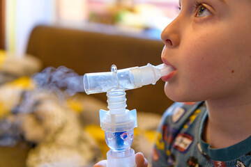 A little boy in selective focus suffering from cough and bronchitis receives breathing treatment...