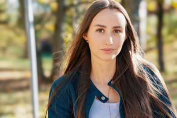 Obraz premium A confident young woman with long brown hair and a happy expression.