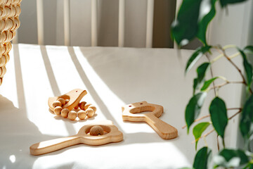 Fototapeta na wymiar Wooden toys rattle in a baby bed