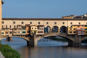 Fototapeta na wymiar The landmark Ponte Vecchio bridge reflected in the Arno River in Florence