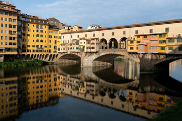 Obraz premium The landmark Ponte Vecchio bridge reflected in the Arno River in Florence