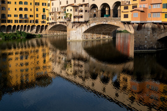 The landmark Ponte Vecchio bridge reflected in the Arno River in Florence