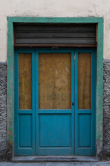 Old blue door with glass windows and green frame